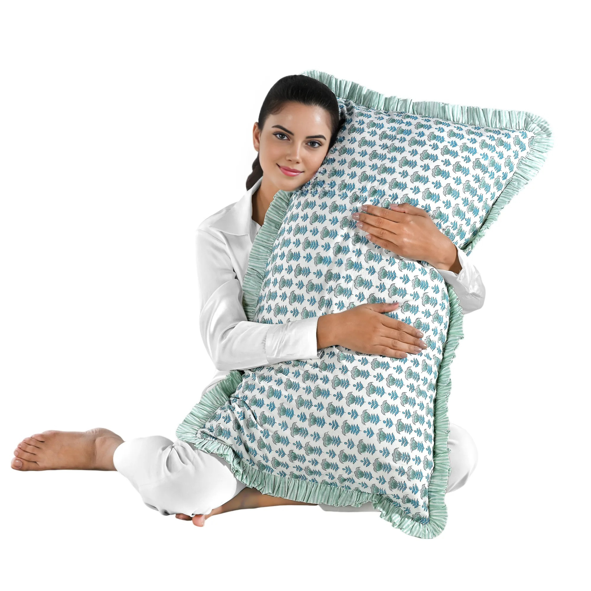 Woman holding a large blue floral block print cotton pillow with green edges.