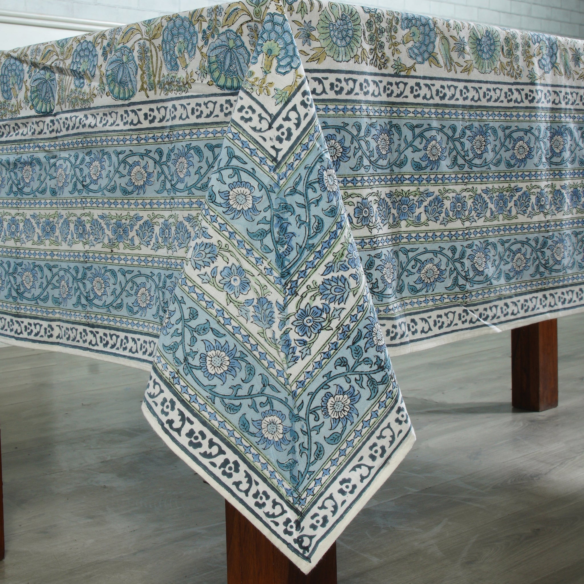 Patterned tablecloth on a wooden table with a neutral background