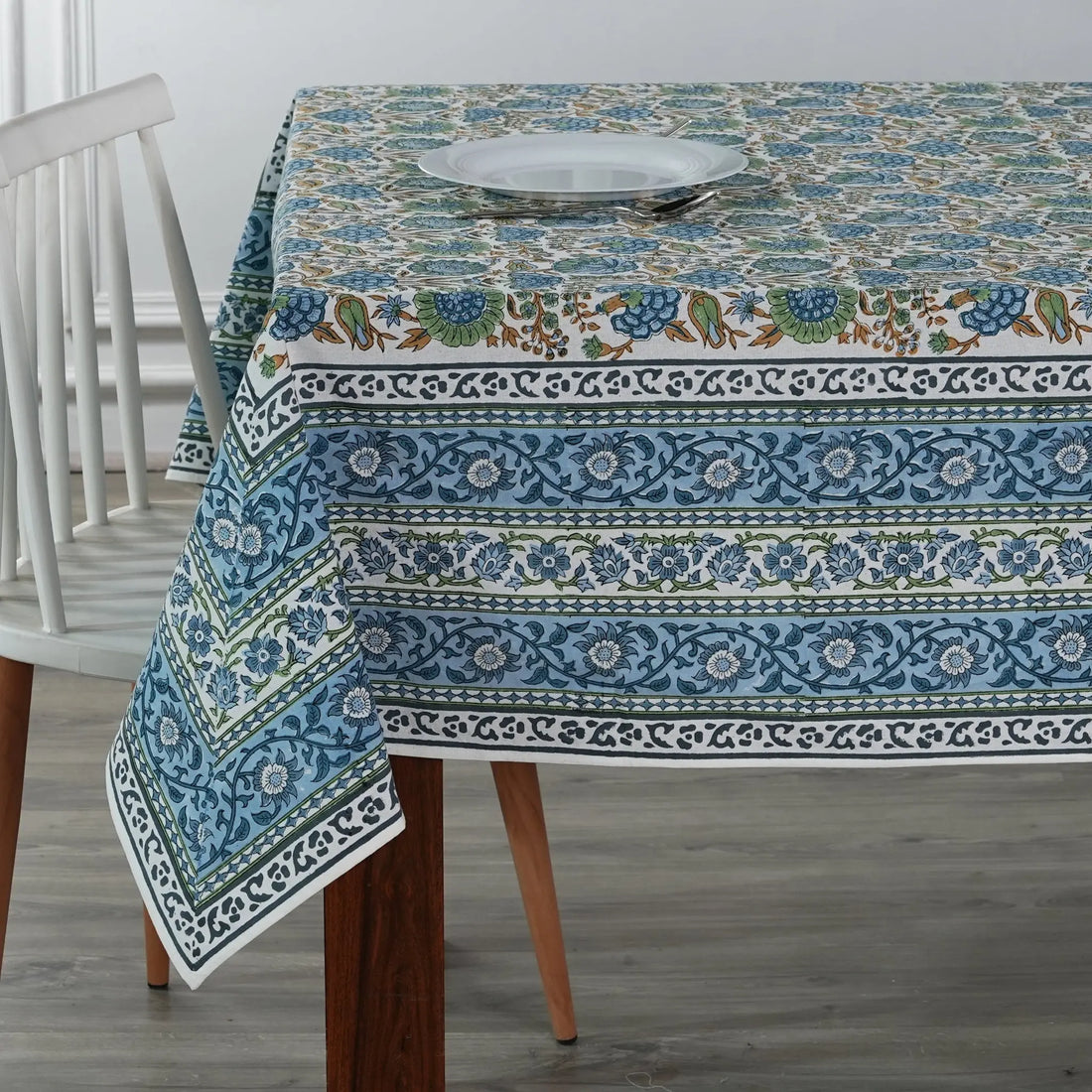 Tablecloth with floral and border design on a wooden table