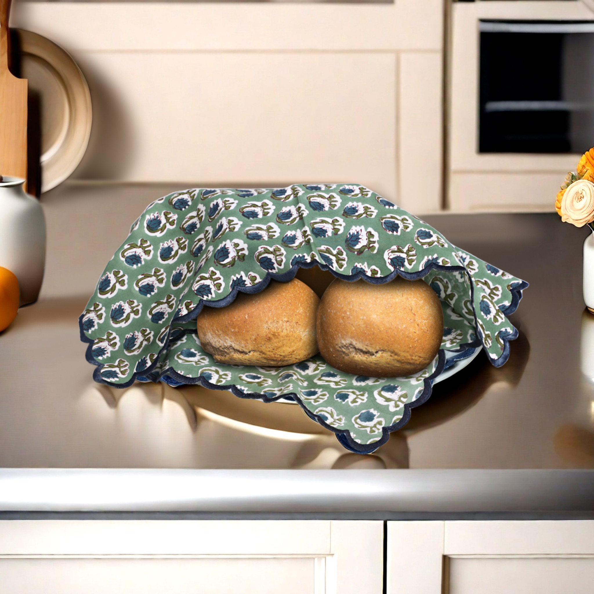 Two loaves of bread wrapped in a floral-patterned cloth on a kitchen counter.