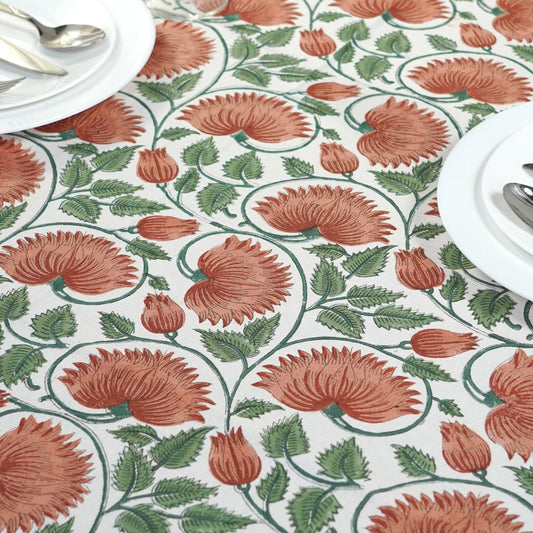 Floral patterned tablecloth with red flowers and green leaves on a white background
