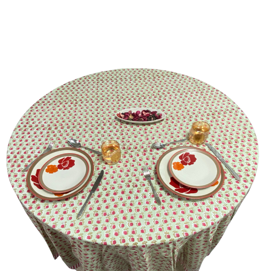 Round table with floral-patterned tablecloth and place settings.