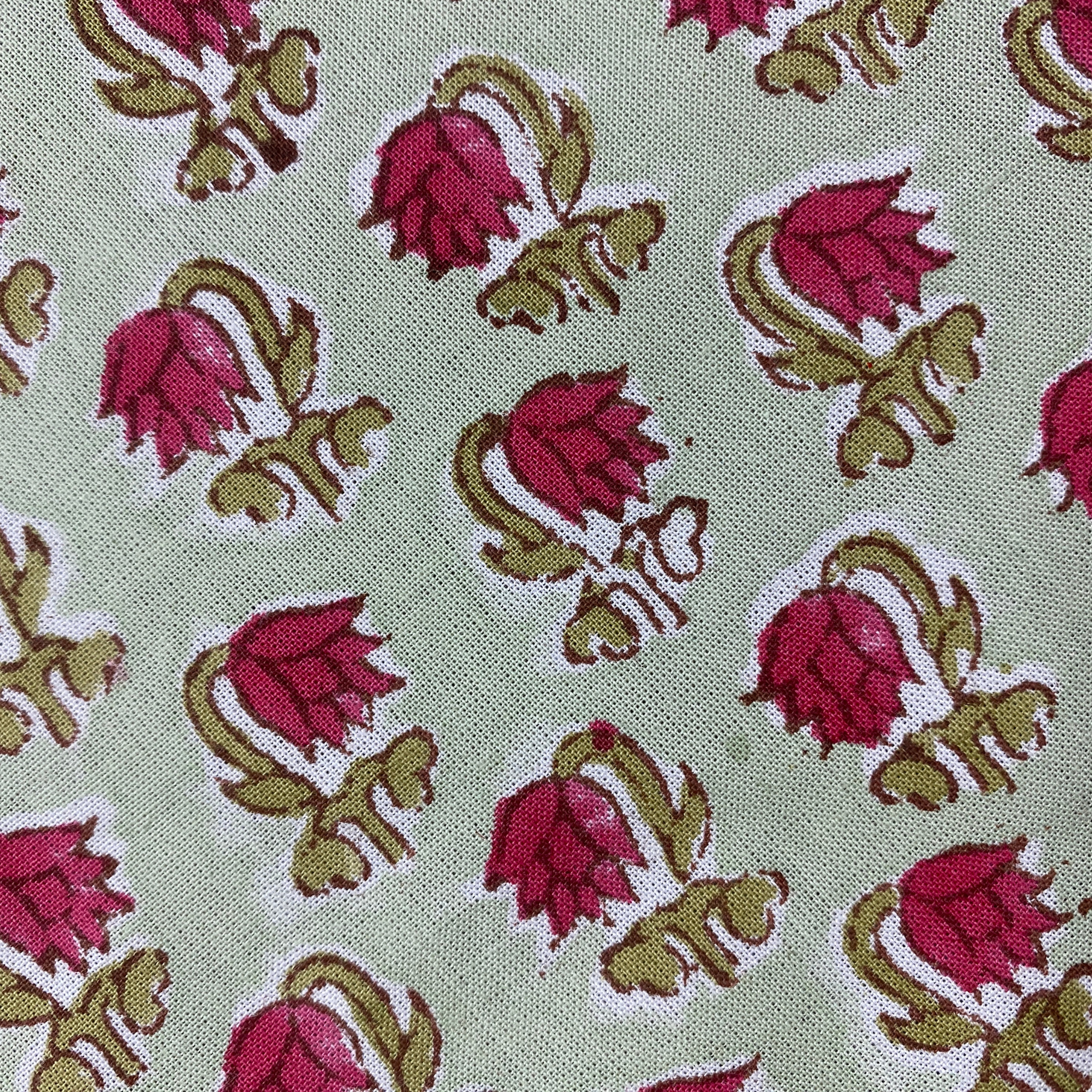 Patterned fabric with pink and green floral design on a light background