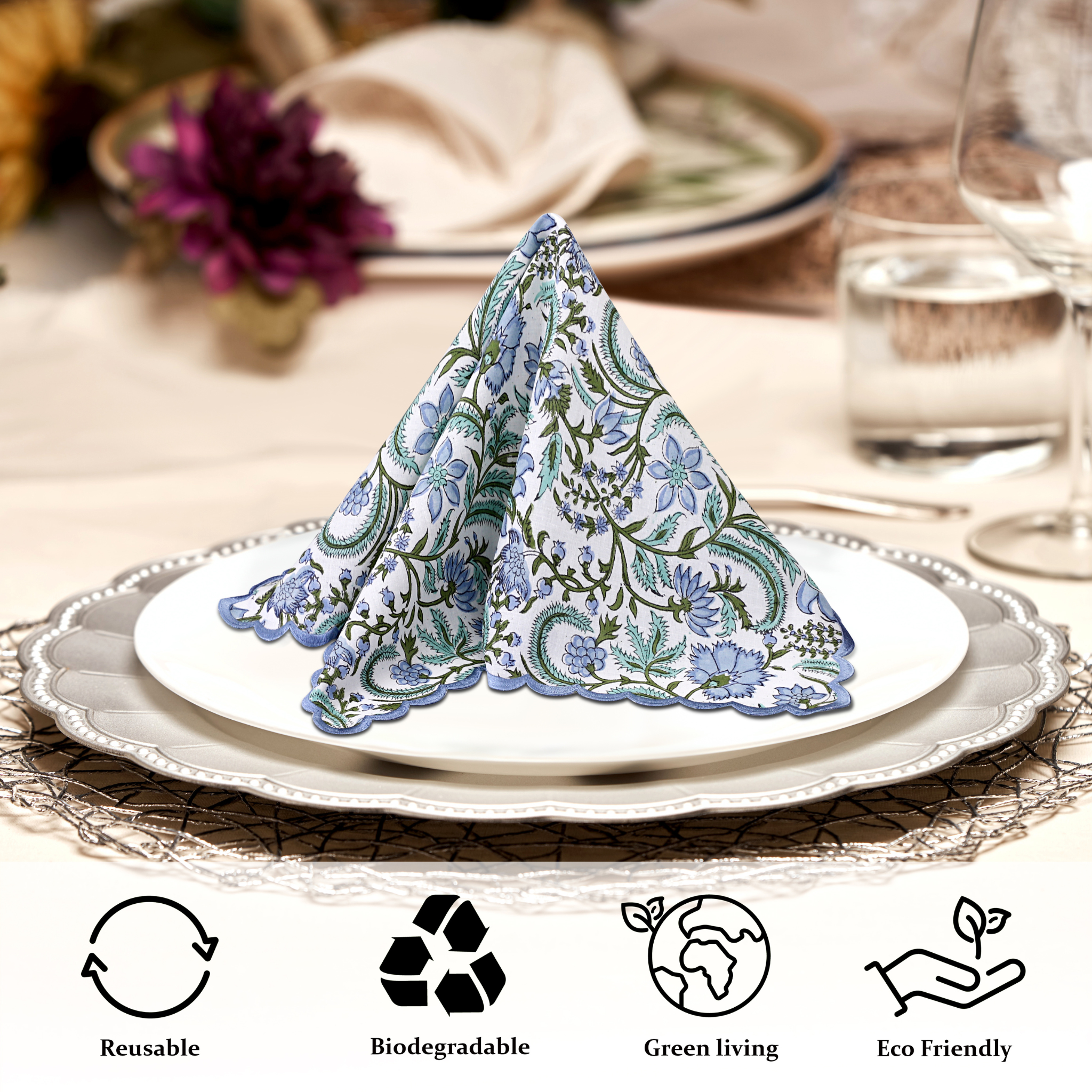 Folded floral napkin on a plate with table setting and product icons indicating sustainability.