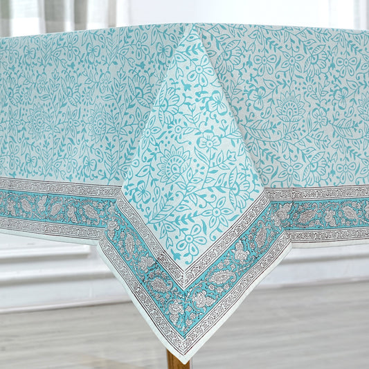 Teal floral patterned tablecloth with decorative border on a white background