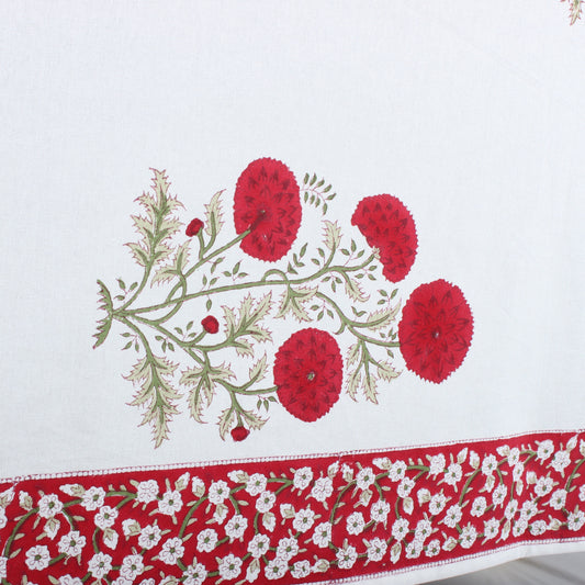 Embroidered tablecloth with red floral design on a white background
