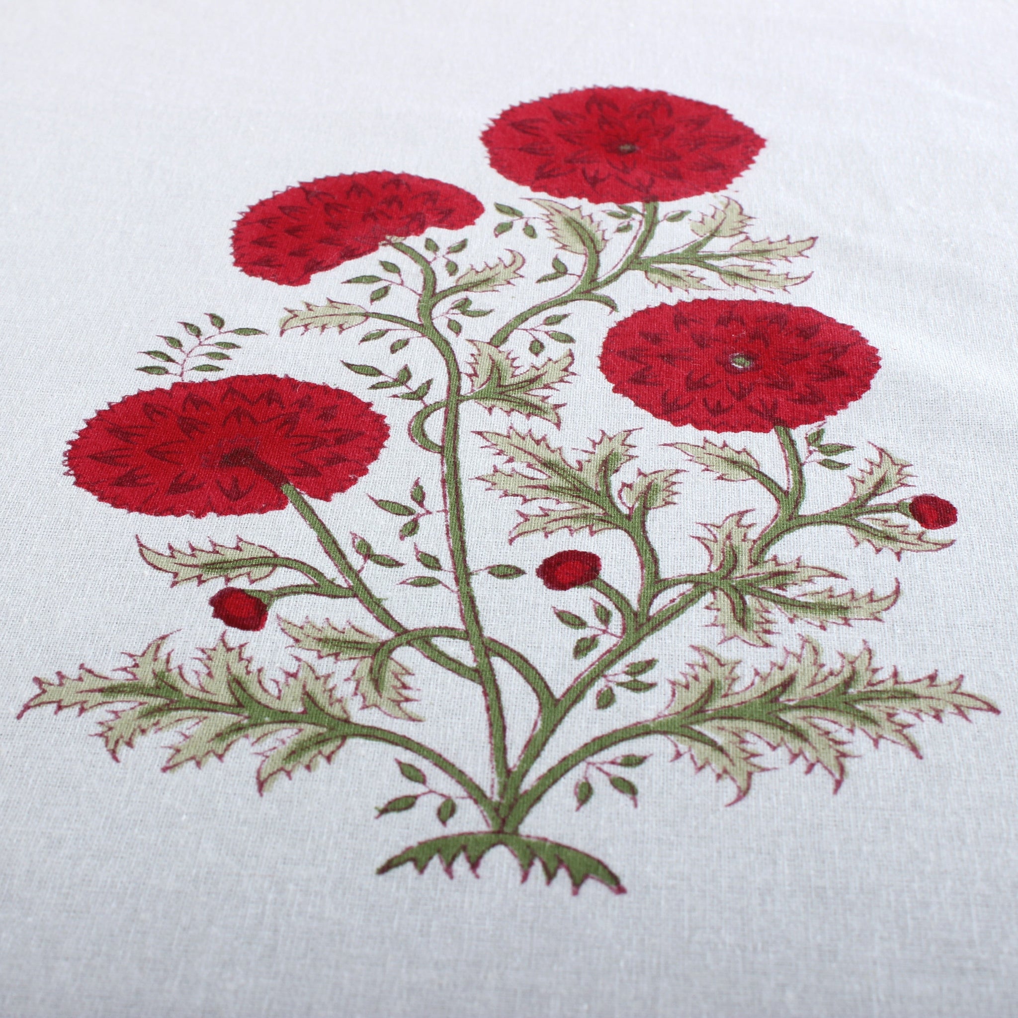Embroidered design of red flowers on a white fabric background