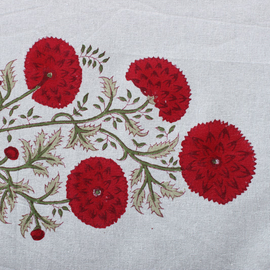 Embroidered design of red flowers and green leaves on a white fabric background