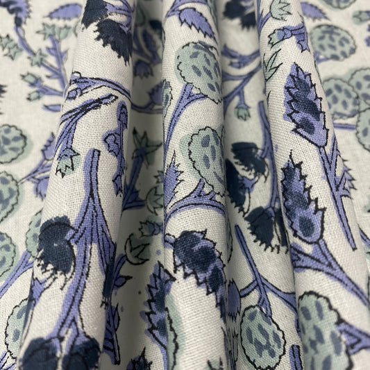 Stack of fabric with blue and green floral pattern on white background