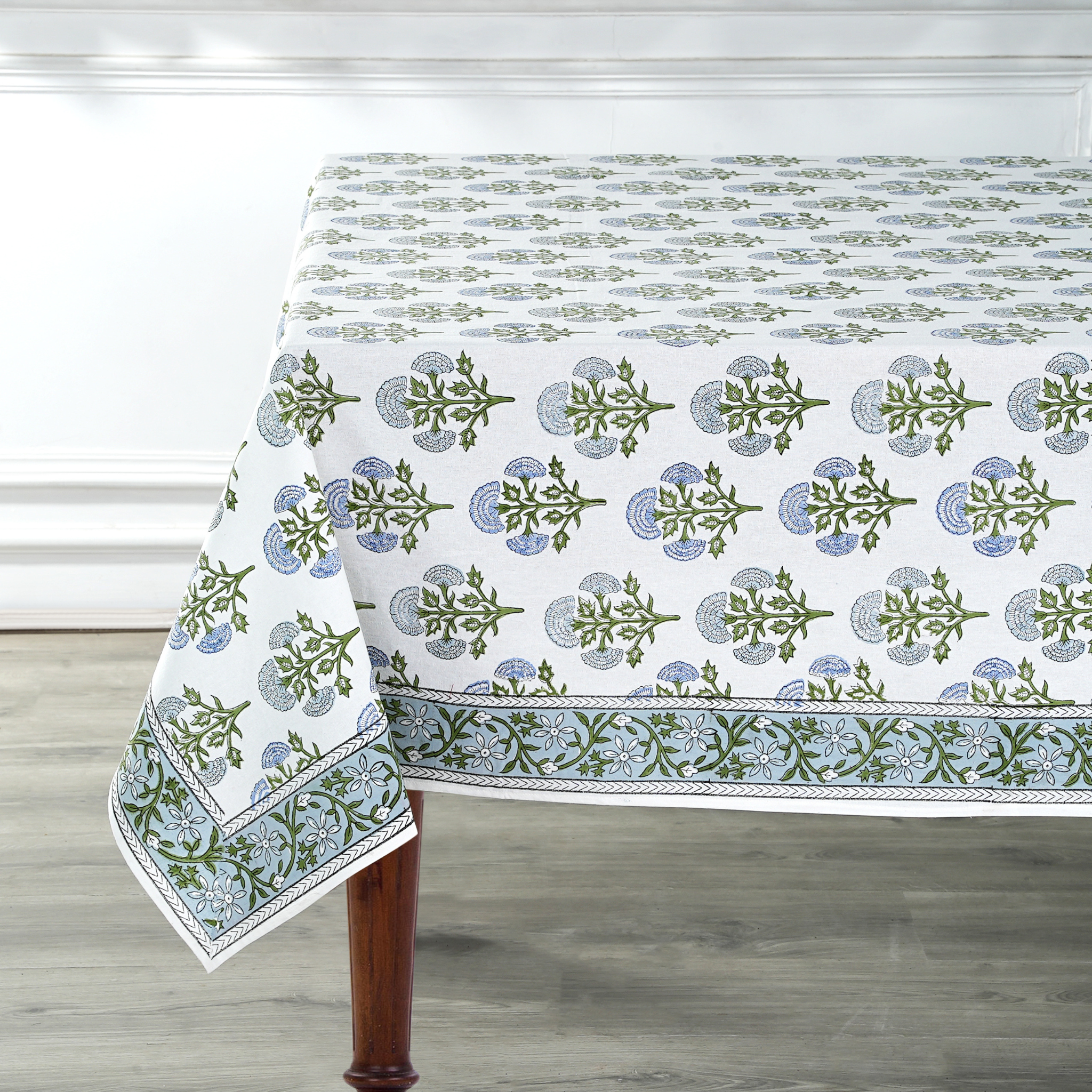 Tablecloth with green floral pattern on a wooden table