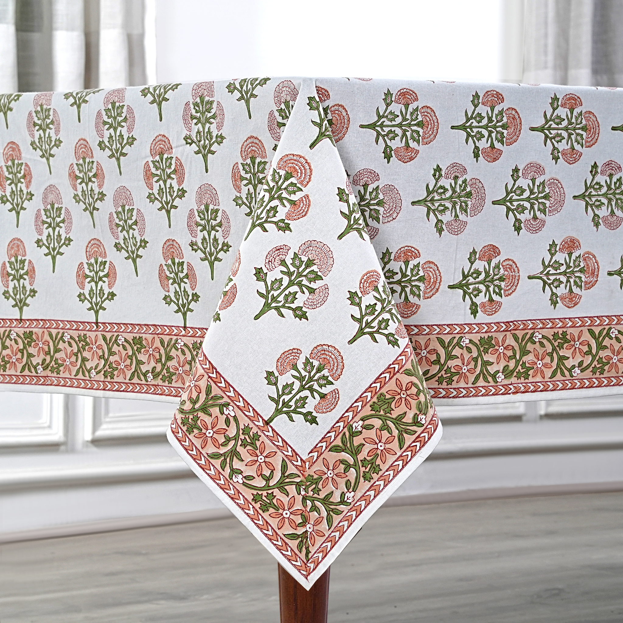 Decorative tablecloth with floral pattern on a wooden table.