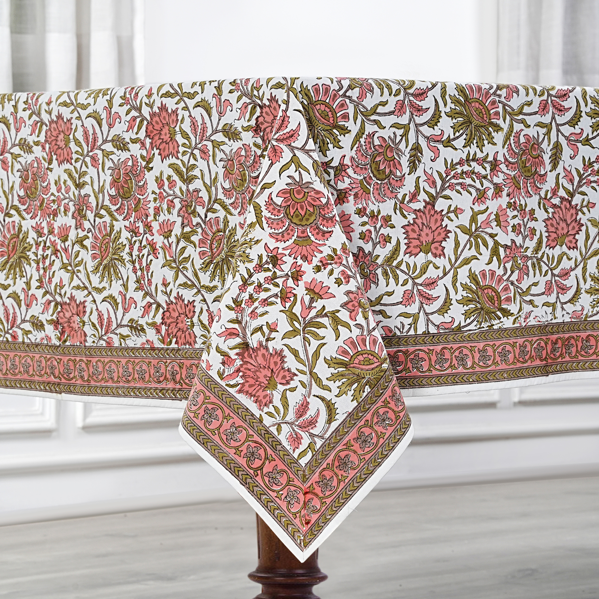 Floral patterned tablecloth on a wooden table with a white background