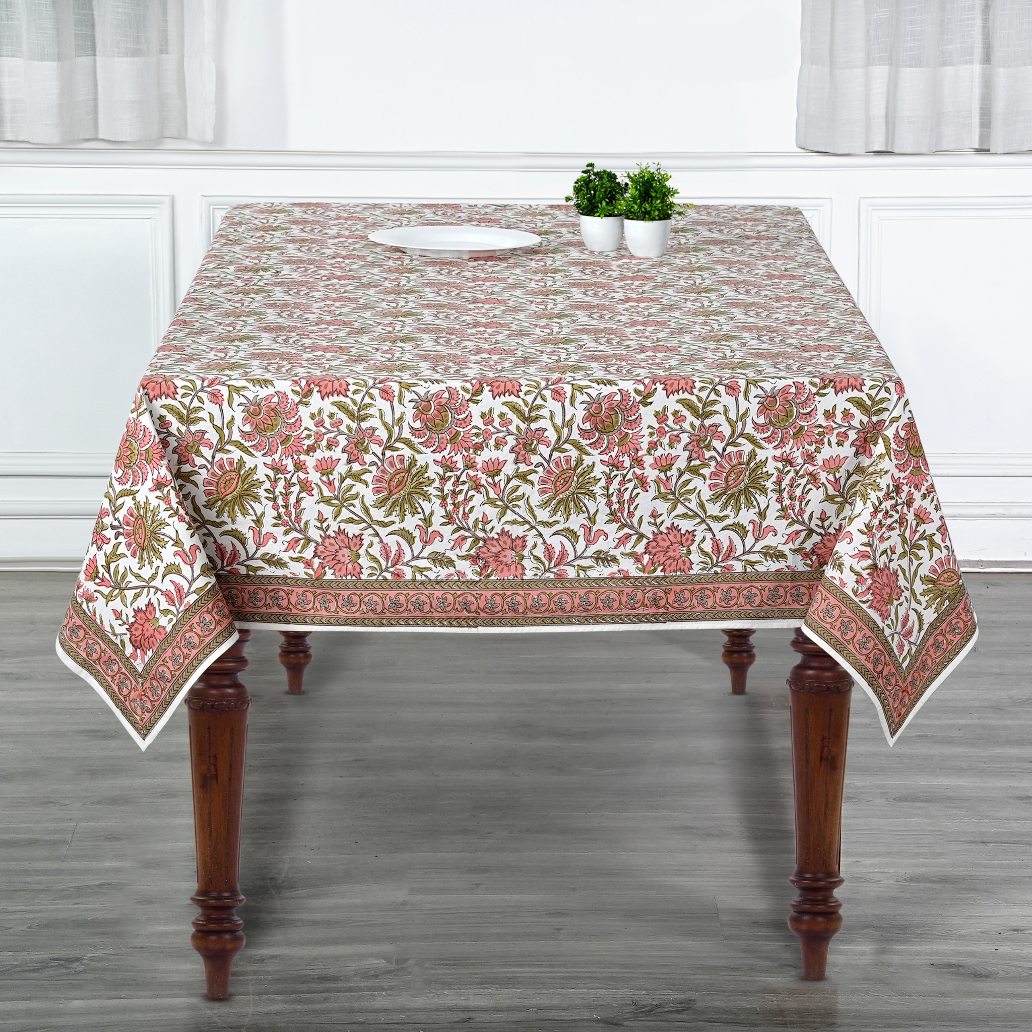 Floral patterned tablecloth on a wooden table with a neutral background