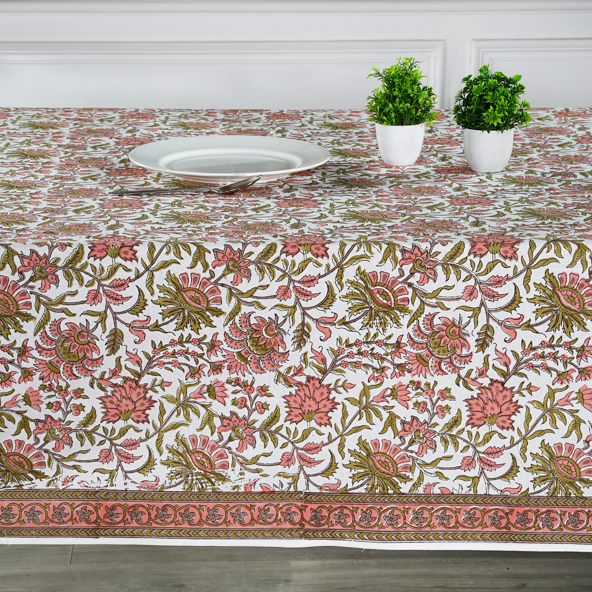 Floral patterned tablecloth on a table with a white wall background