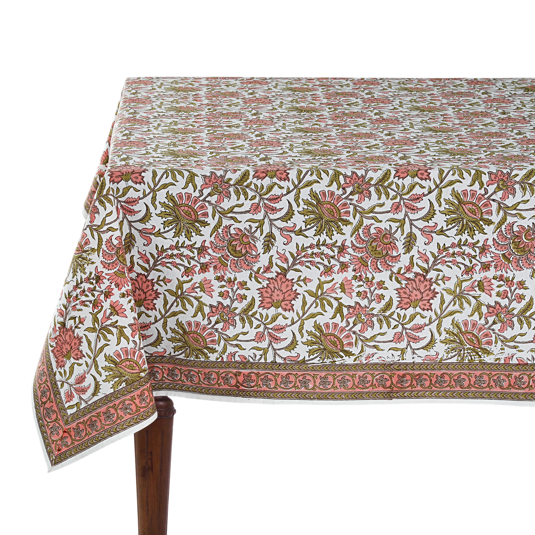 Floral patterned tablecloth on a wooden table with a white background
