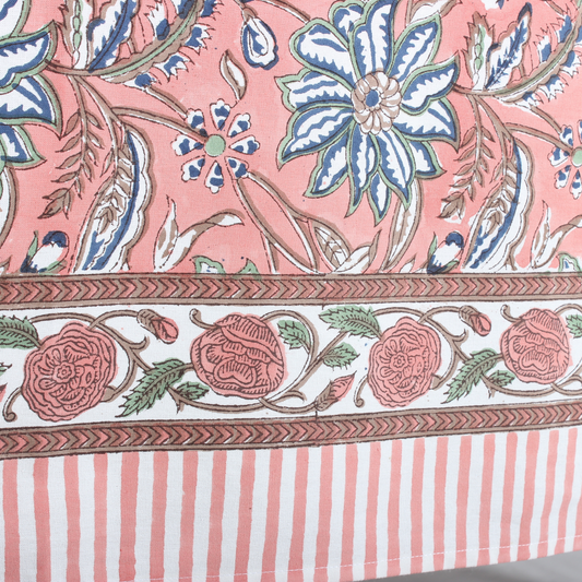 Close-up of a fabric with floral and striped patterns on a pink background