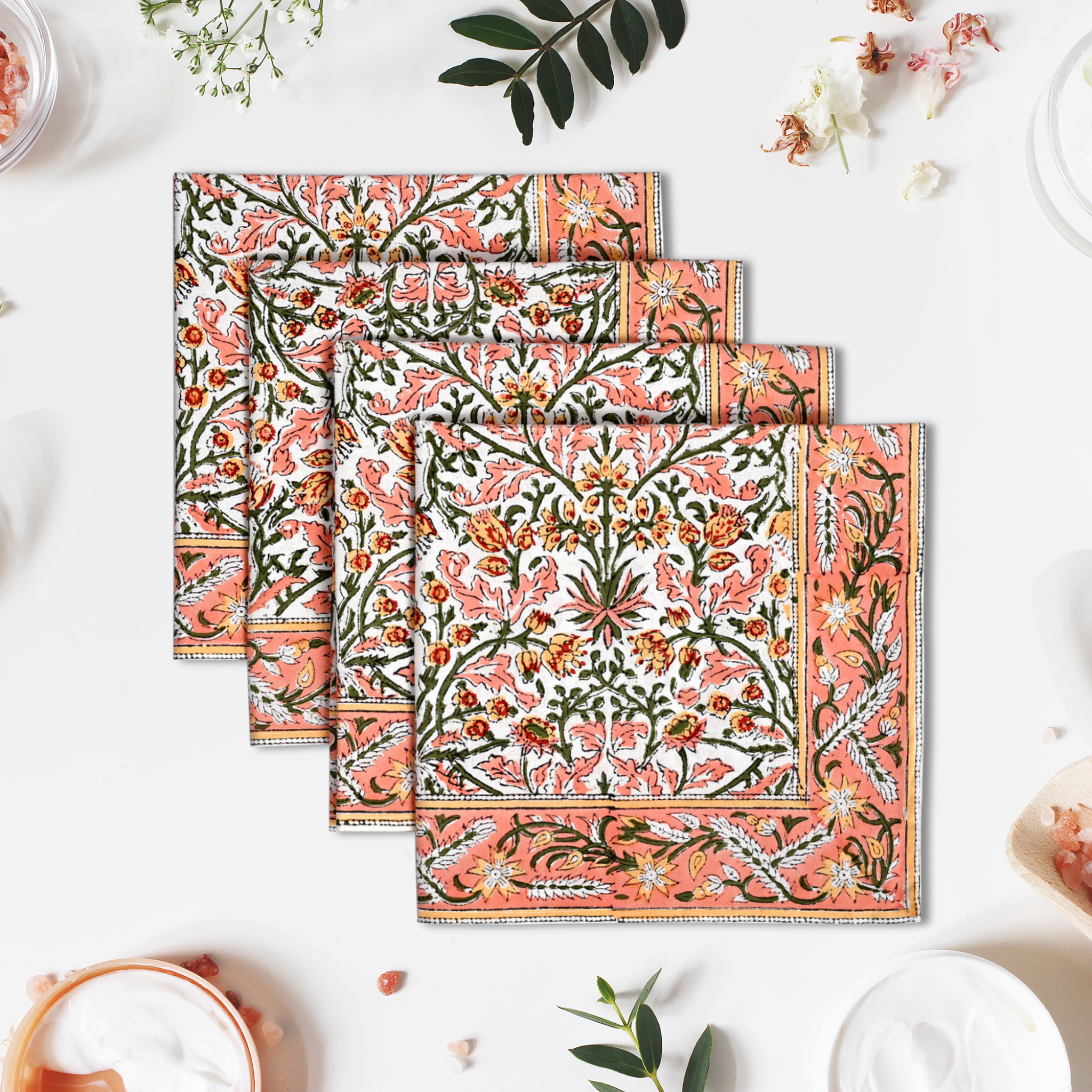Set of four floral patterned placemats on a white surface with decorative elements.