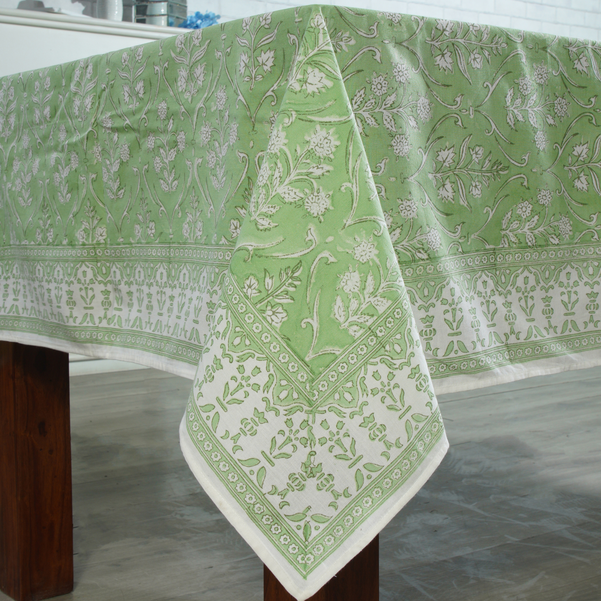 Green and white patterned tablecloth on a wooden table