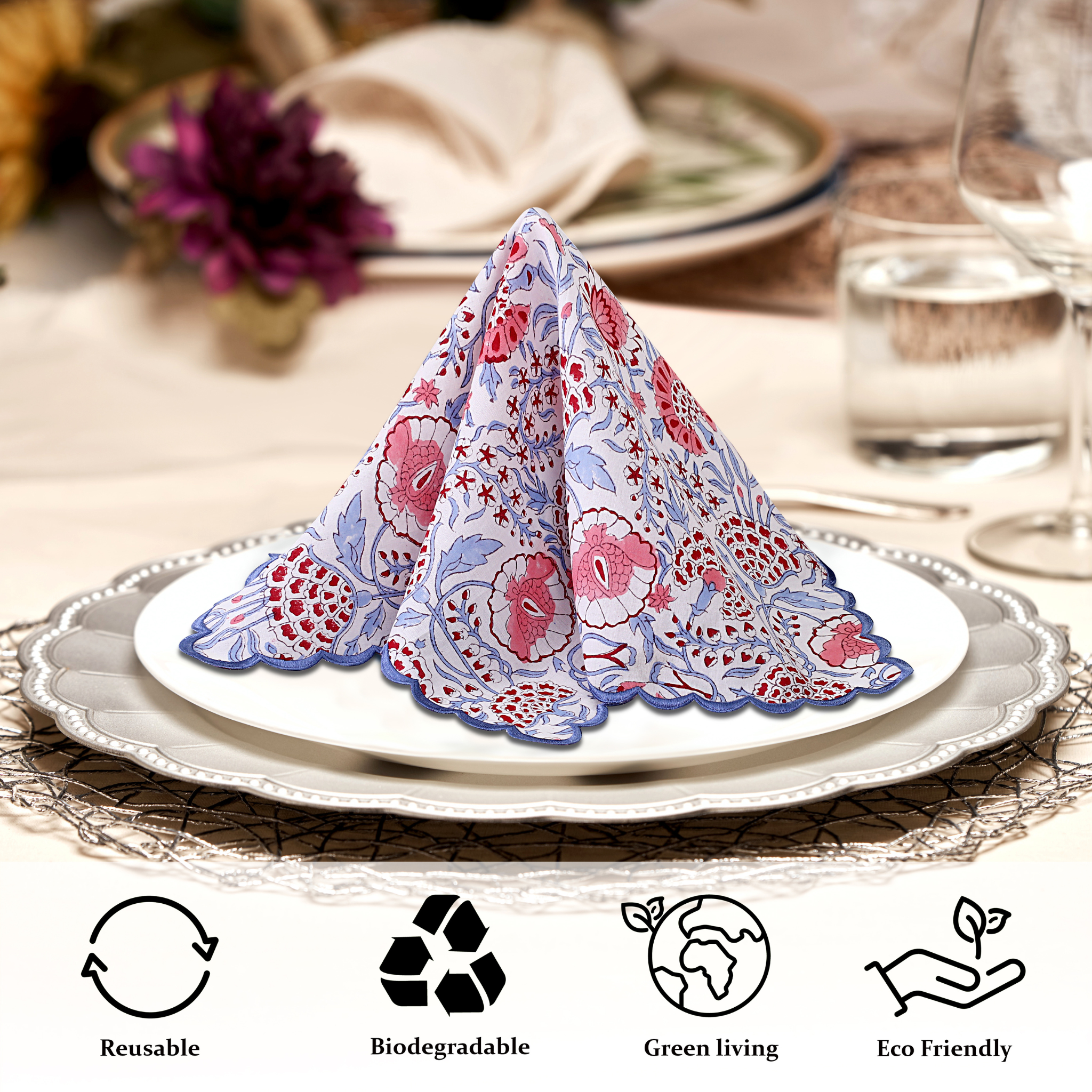 Floral-patterned napkin folded into a triangle on a white plate with a table setting in the background.
