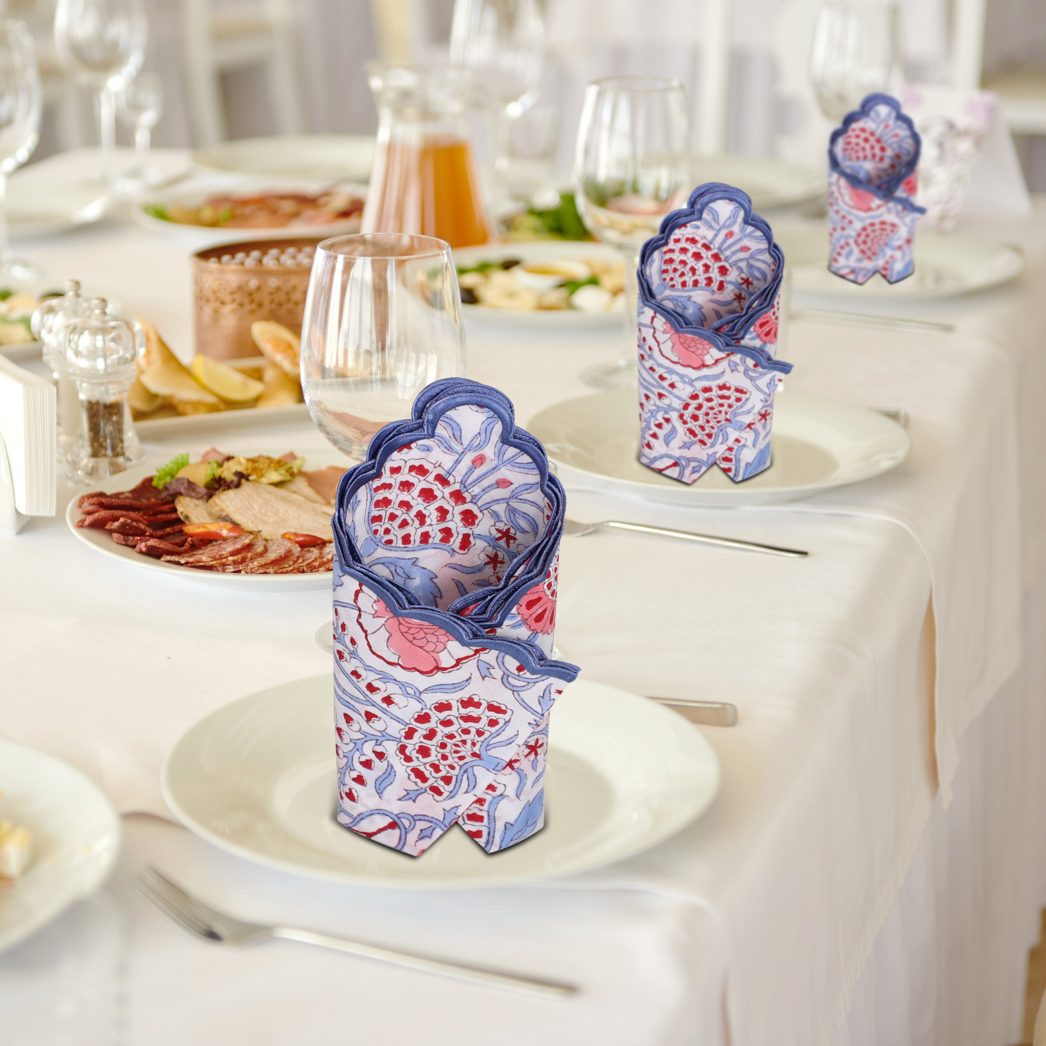 Decorative folded napkins on a table setting with plates and glasses.