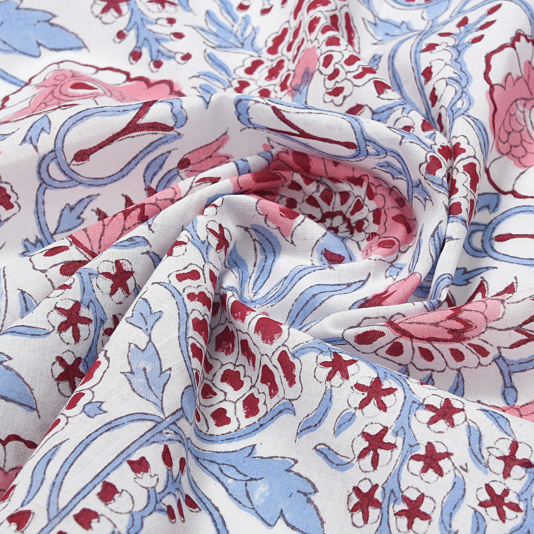Close-up of patterned fabric with red, blue, and pink colors on a white background
