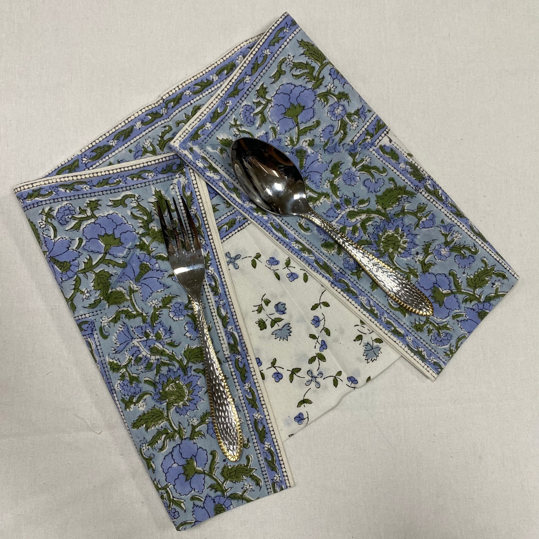 Floral-patterned placemat with cutlery on a neutral background