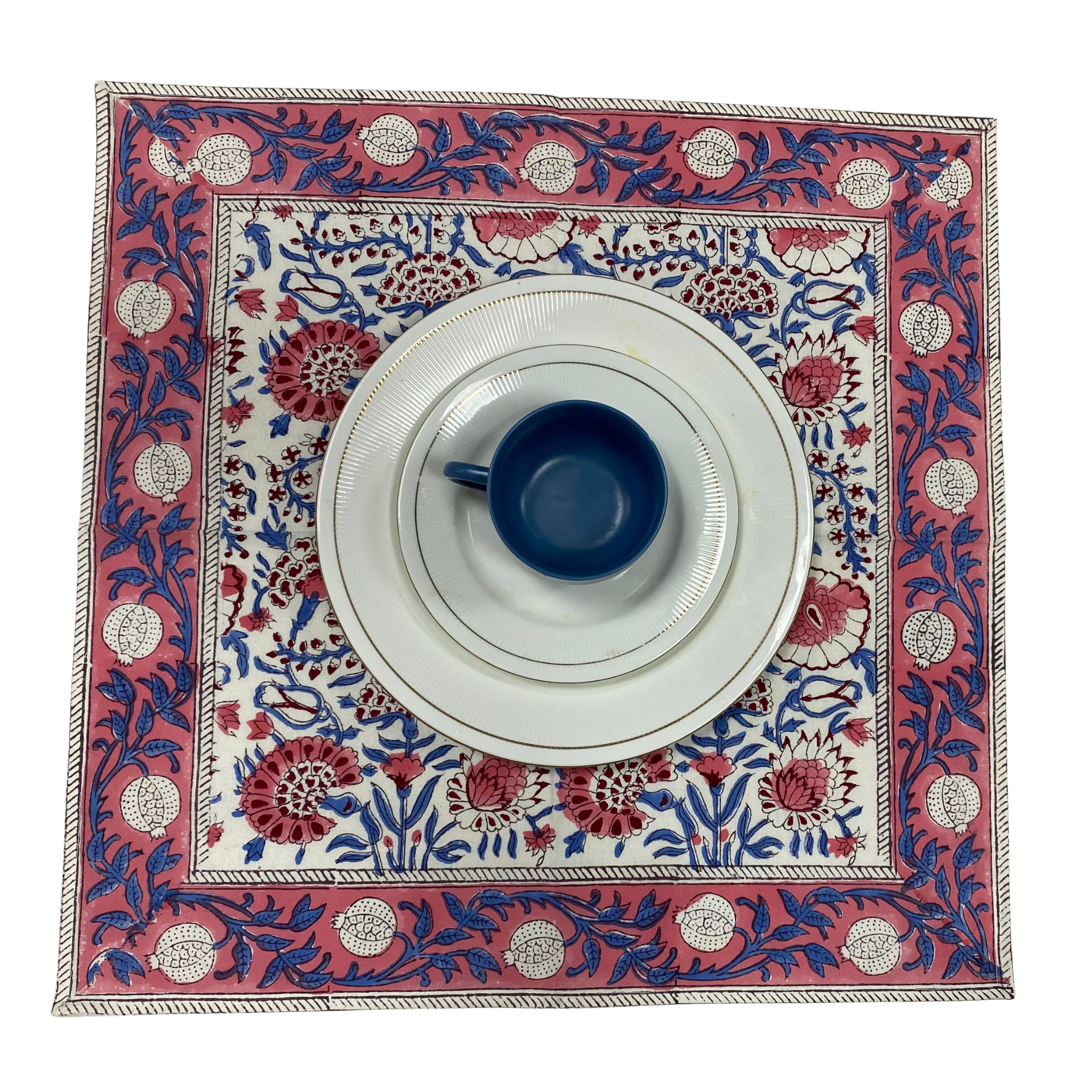 Decorative table mat with floral patterns and a blue cup on a white background