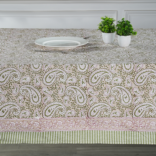 Tablecloth with paisley pattern on a dining table with plants and a plate.
