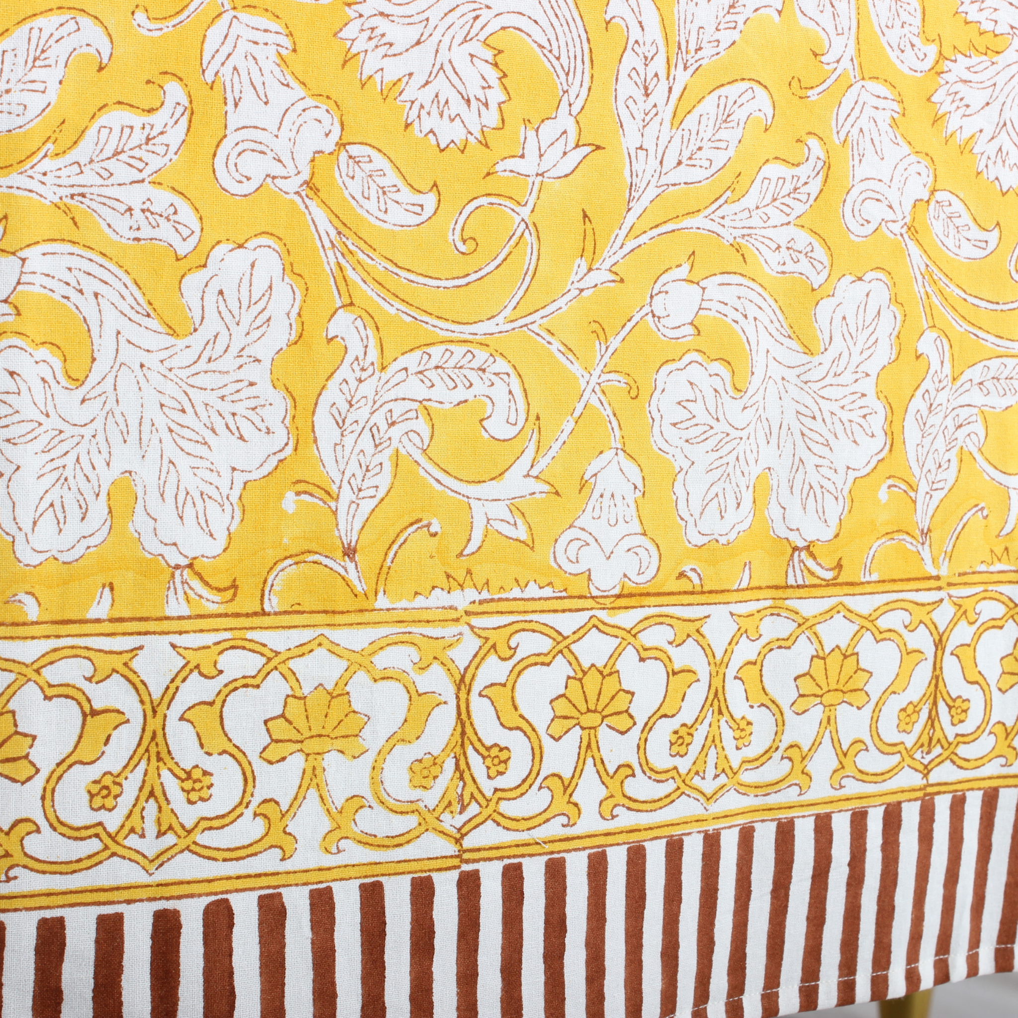 Close-up of a fabric with white floral patterns on a yellow background