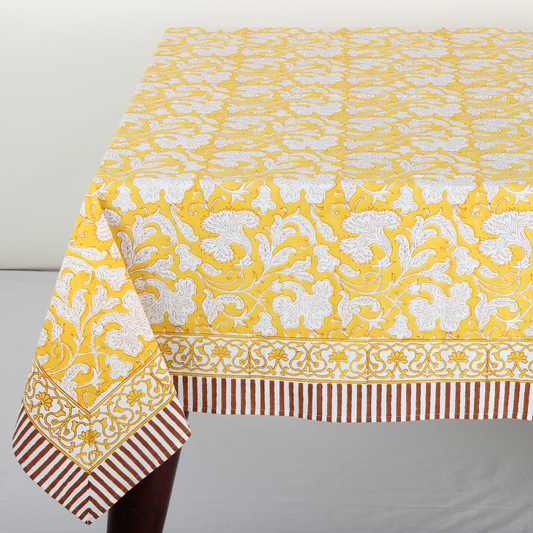 Yellow floral patterned tablecloth with white and red border on a gray background