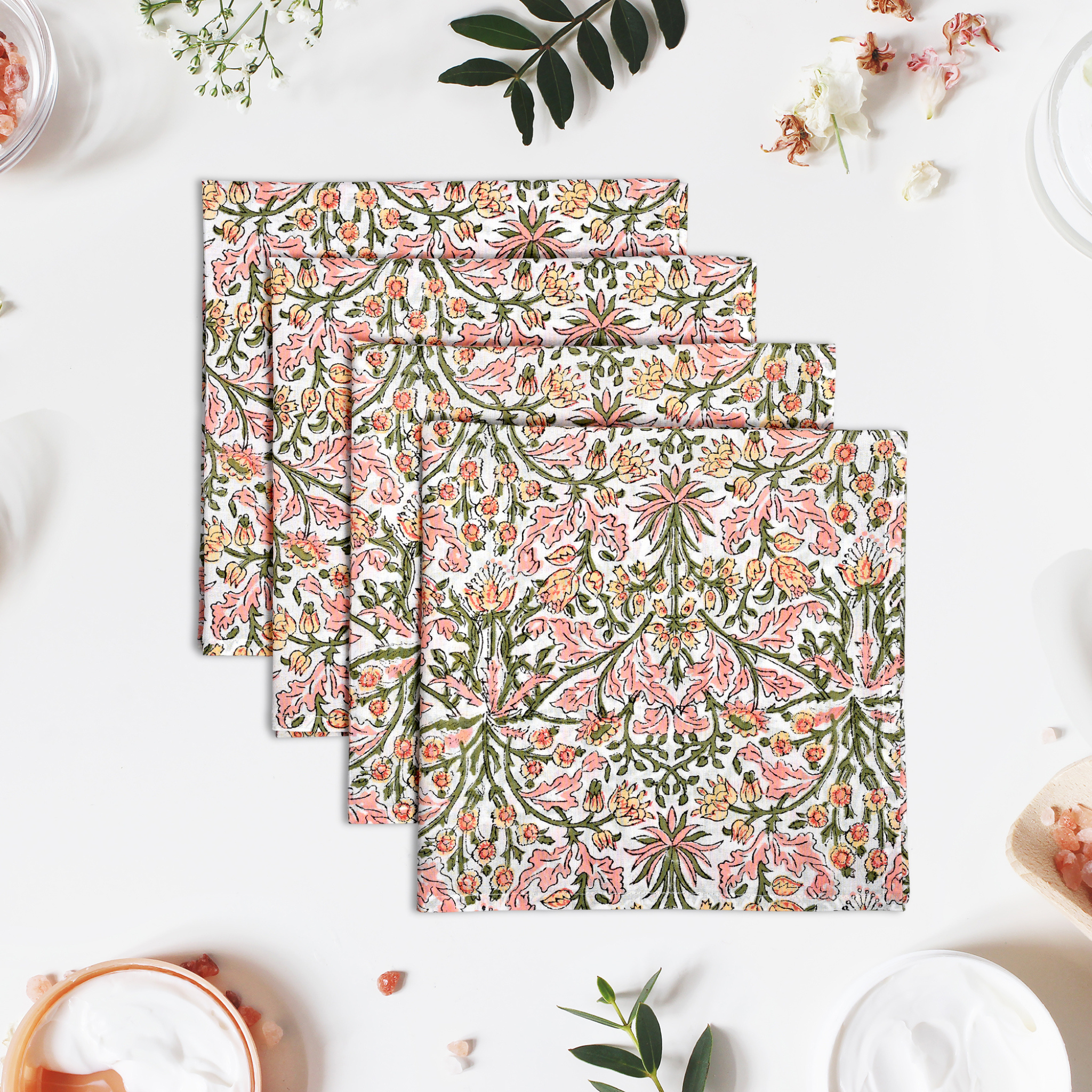 Set of floral patterned placemats on a white surface with decorative elements.