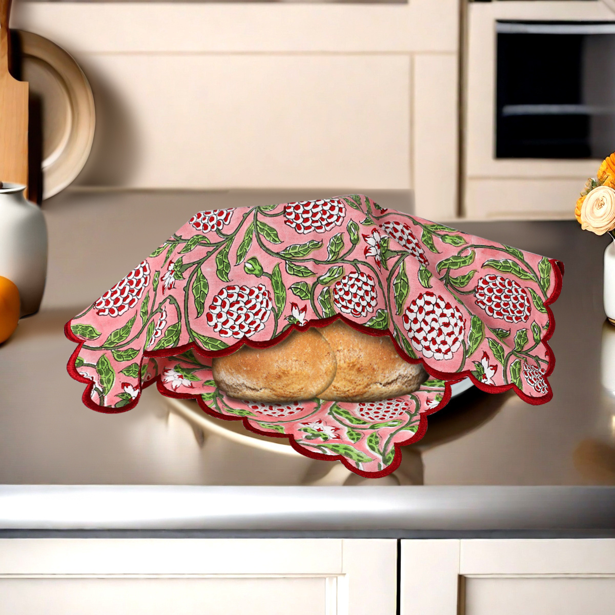 Decorative pink and green lid covering a dish on a kitchen counter.