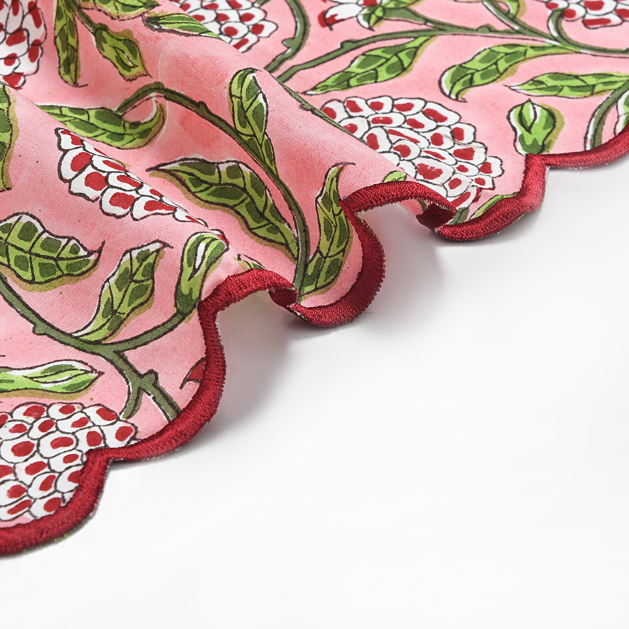 Close-up of a pink fabric with red and green floral pattern