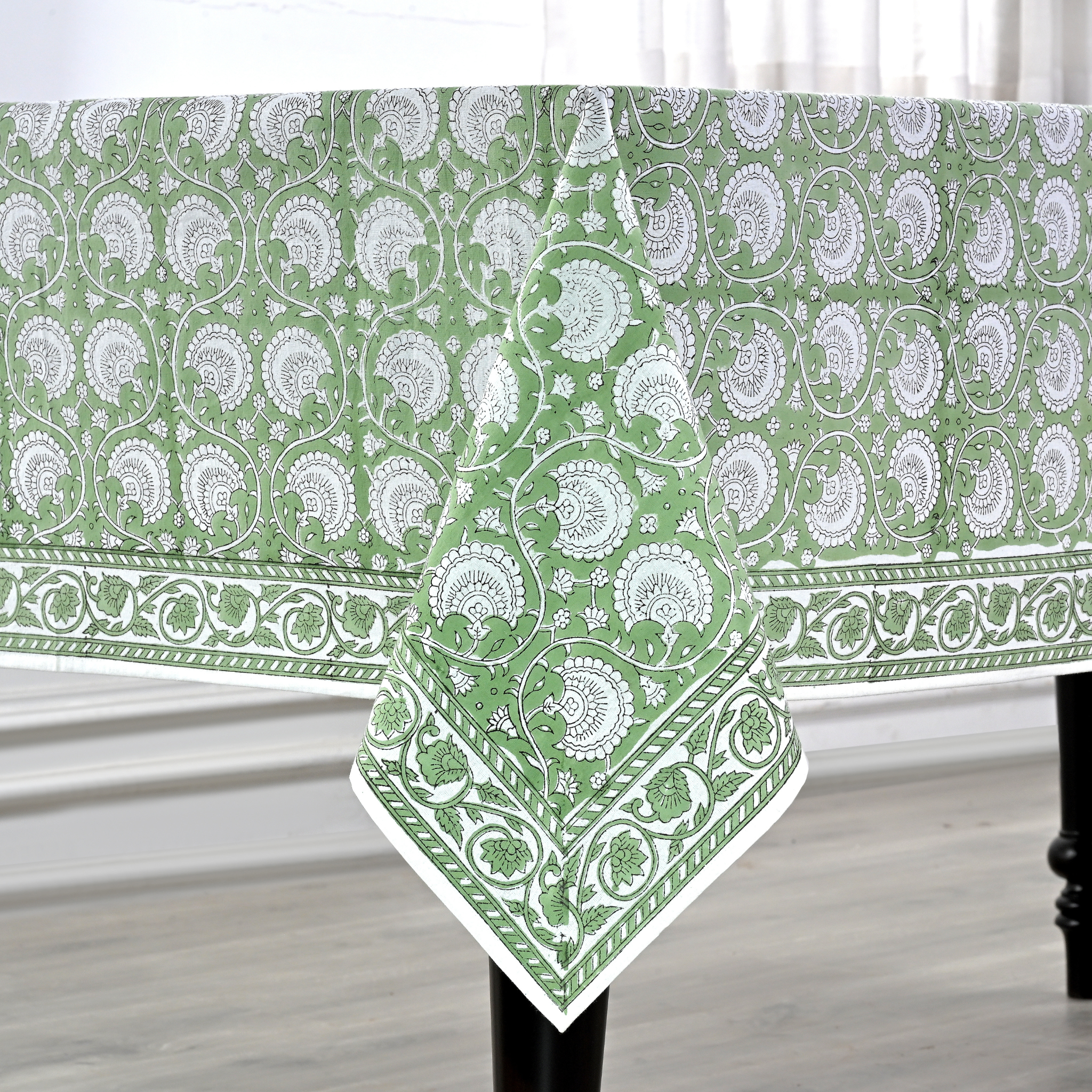 Green and white patterned tablecloth on a wooden table.