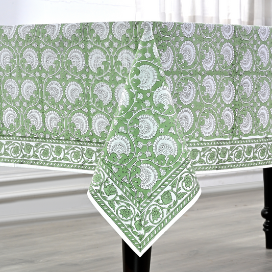 Green and white patterned tablecloth on a wooden table.