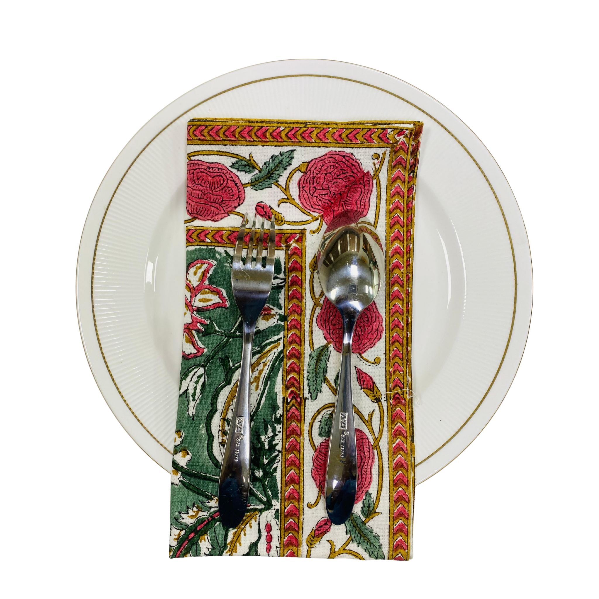 Decorative napkin with floral pattern holding a fork and spoon on a white plate.