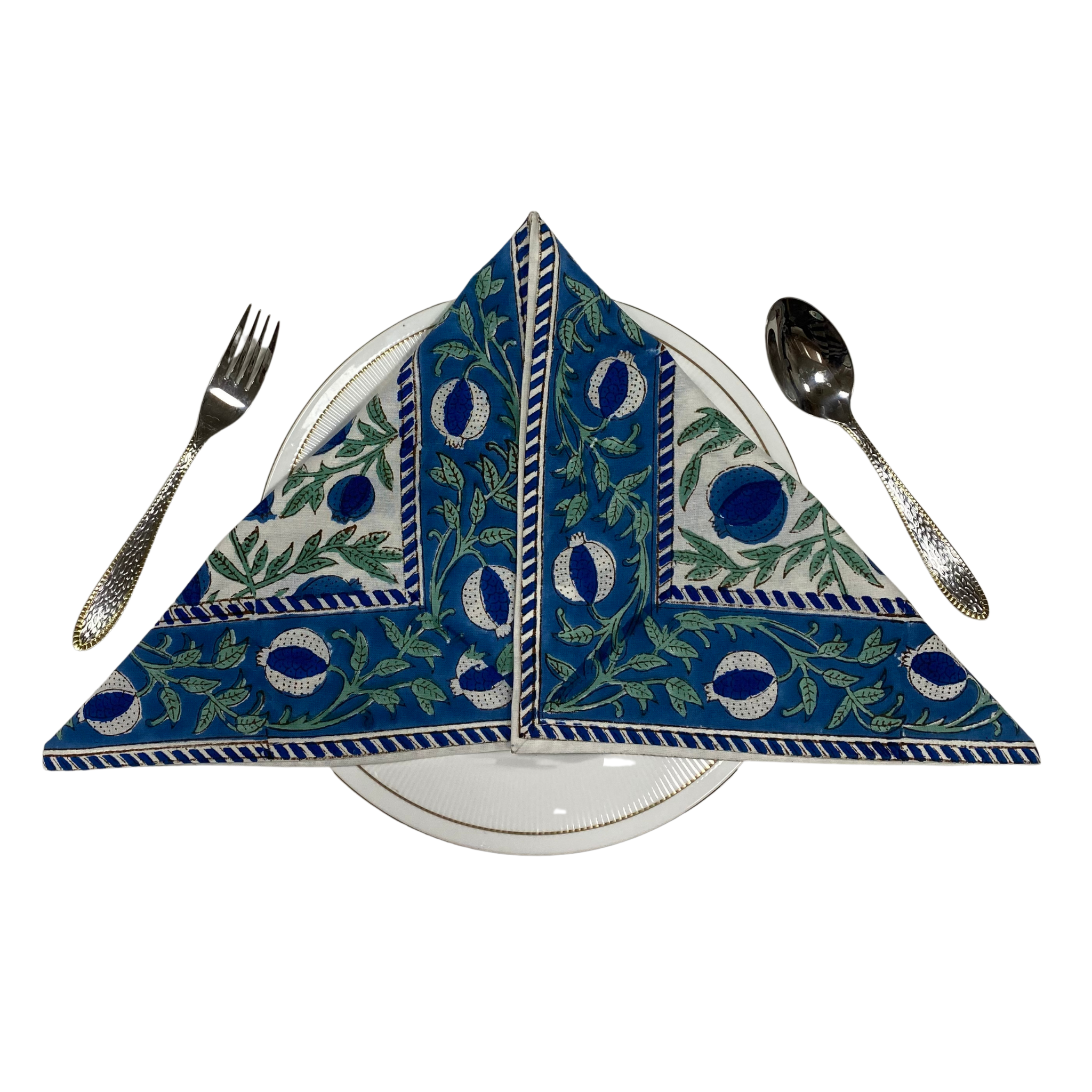 Decorative blue and white napkin on a white plate with silverware