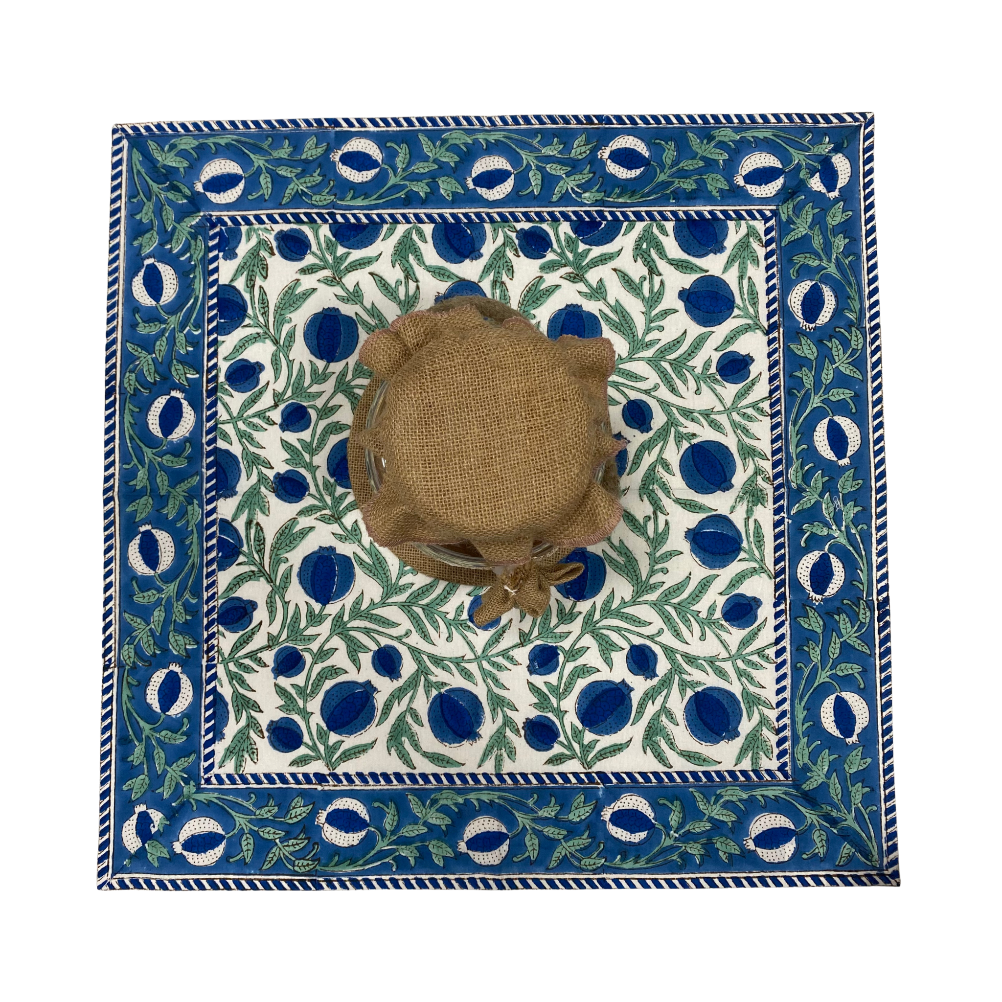 Decorative tablecloth with blue and green pattern on a white background