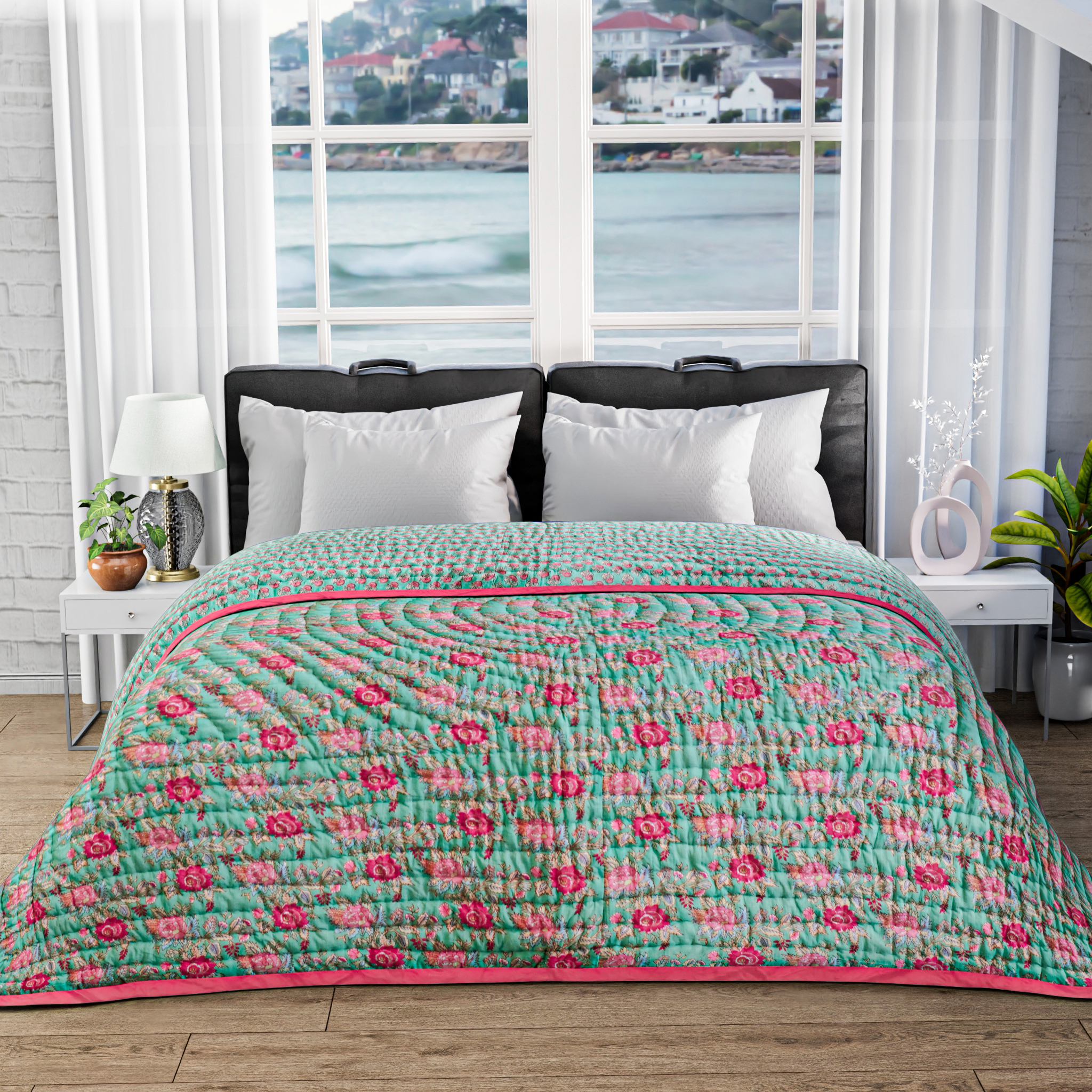 Bed with floral quilt in a room with large windows showing a waterfront view.