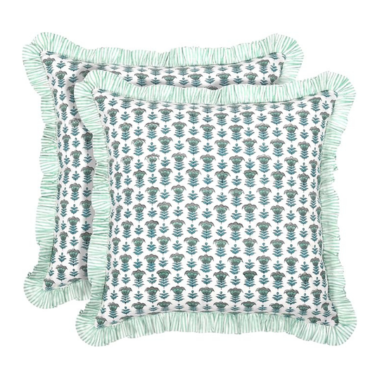 Two decorative pillows with floral patterns and fringes on a white background