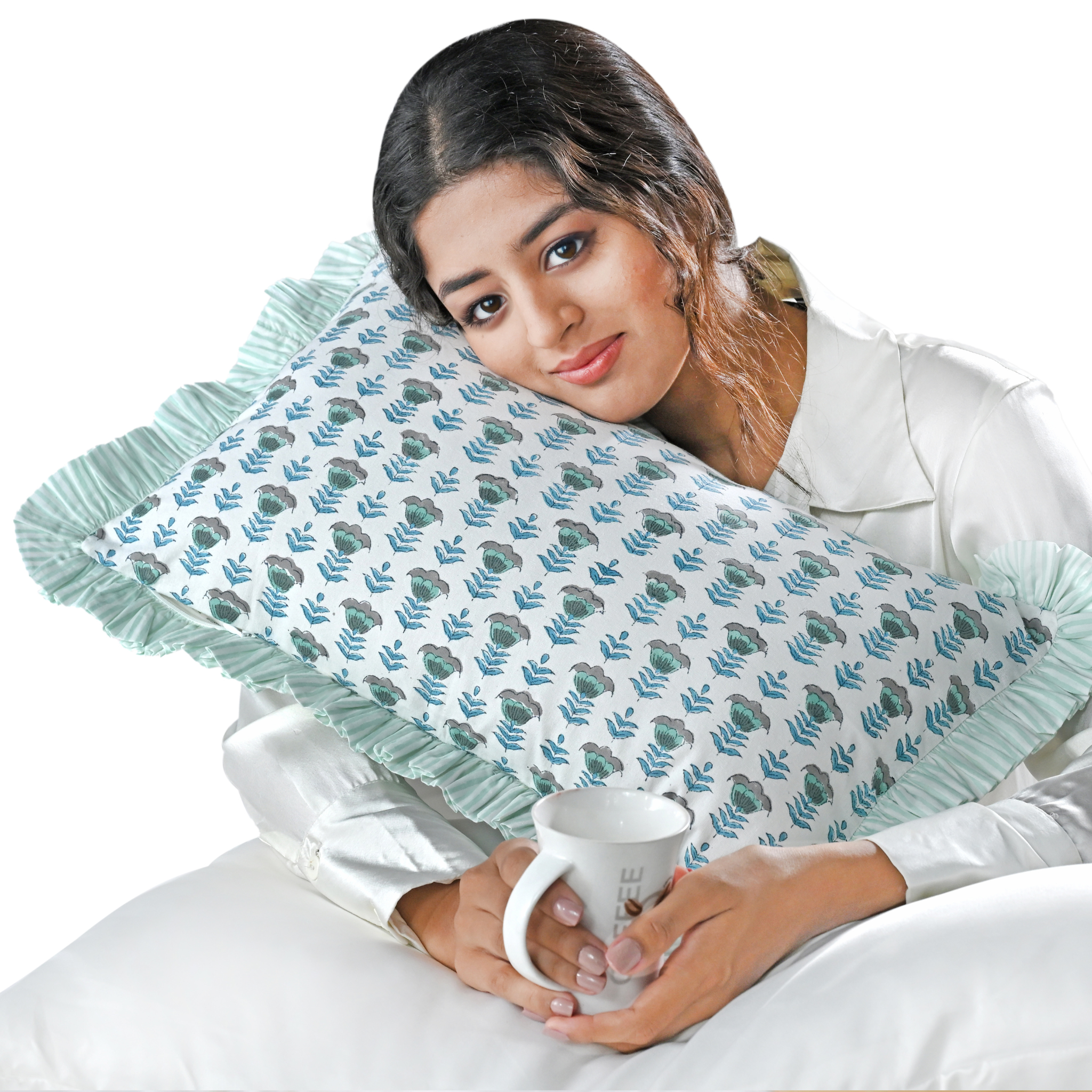 Woman holding a mug with a decorative pillow featuring floral patterns.