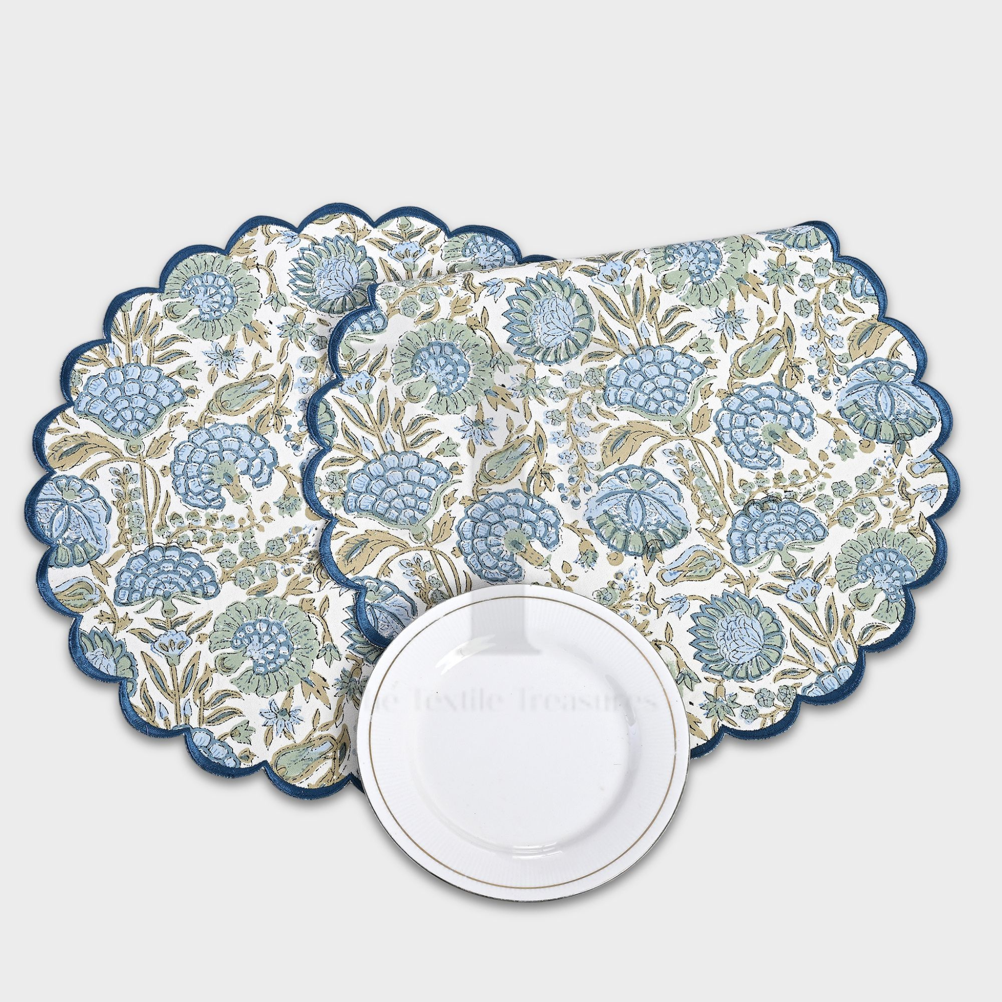 Floral patterned placemats with scalloped edges on a white background