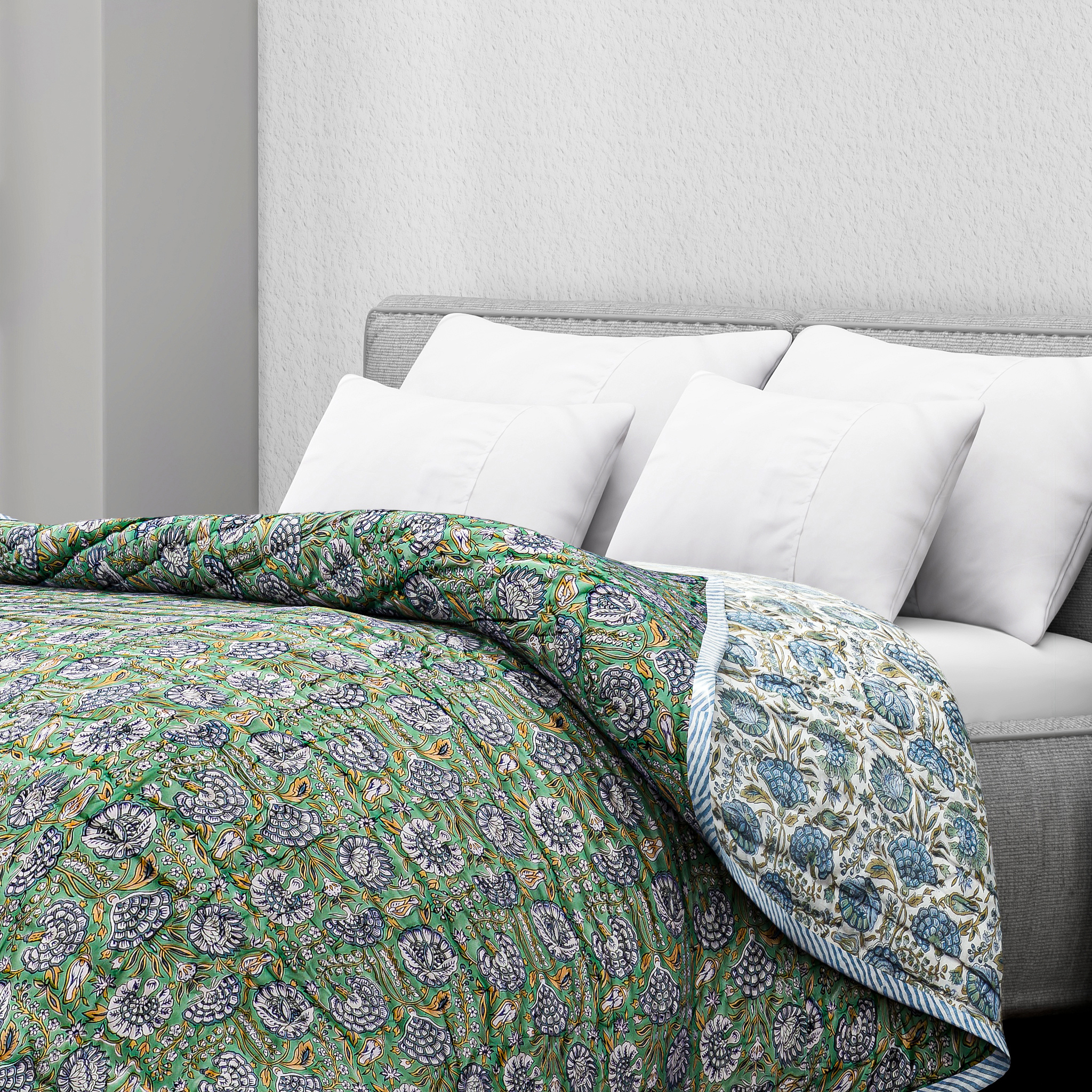 Floral patterned comforter on a bed with white pillows and a gray headboard.