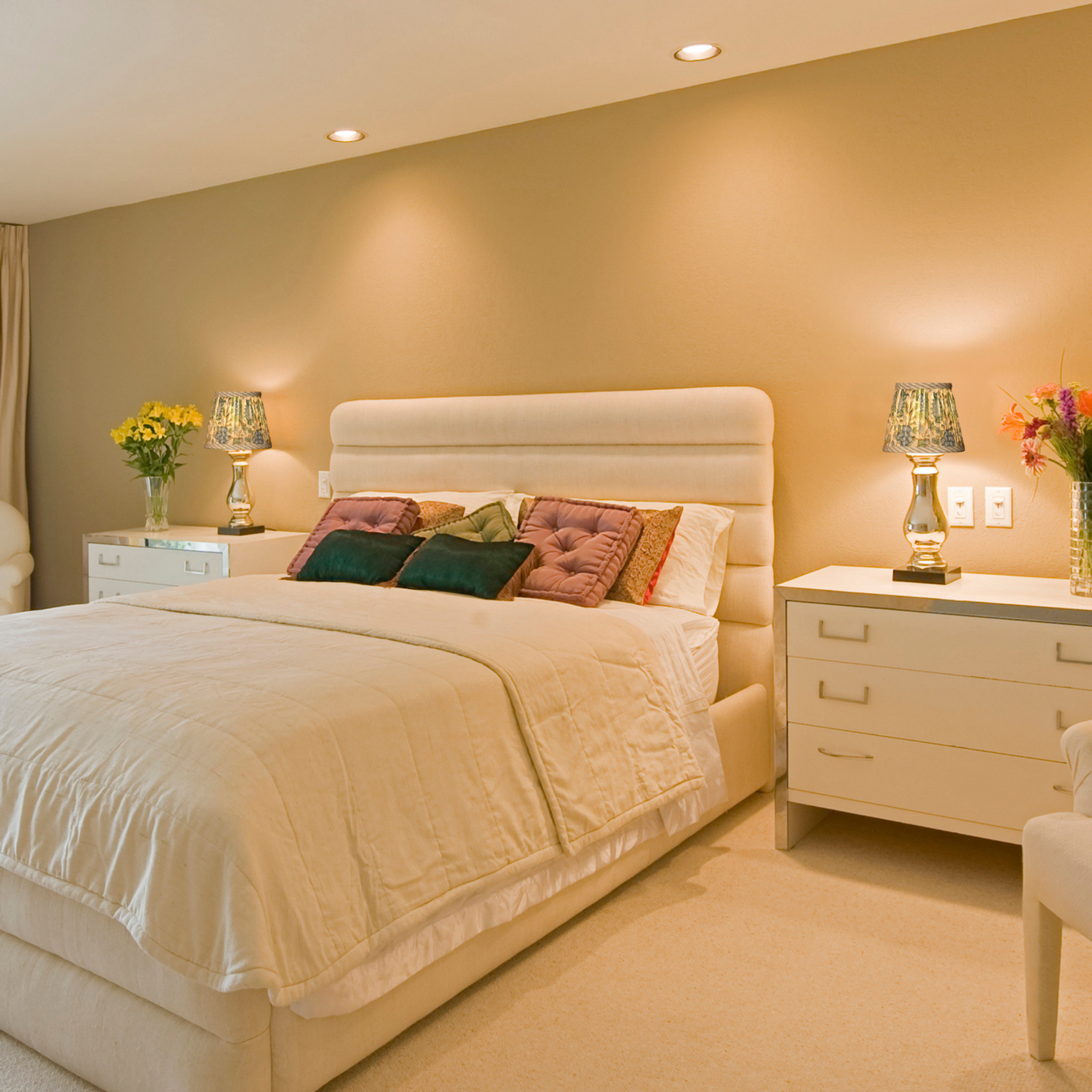 Neatly made bed with decorative pillows in a bedroom setting.