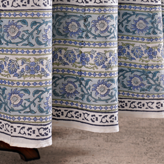 Close-up of floral patterned fabric with blue and green designs on a neutral background