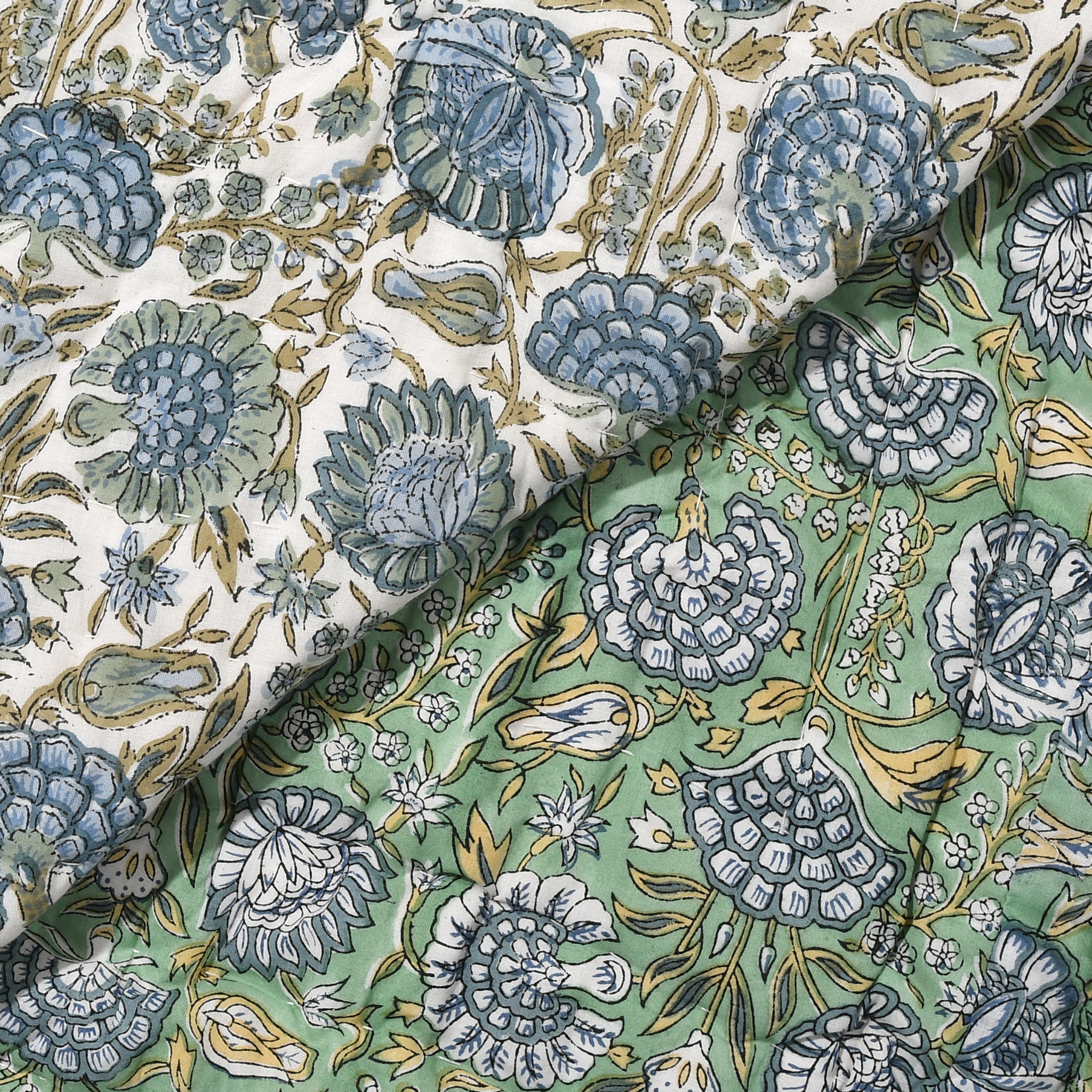 Close-up of floral fabric with blue and green patterns on a textured surface.