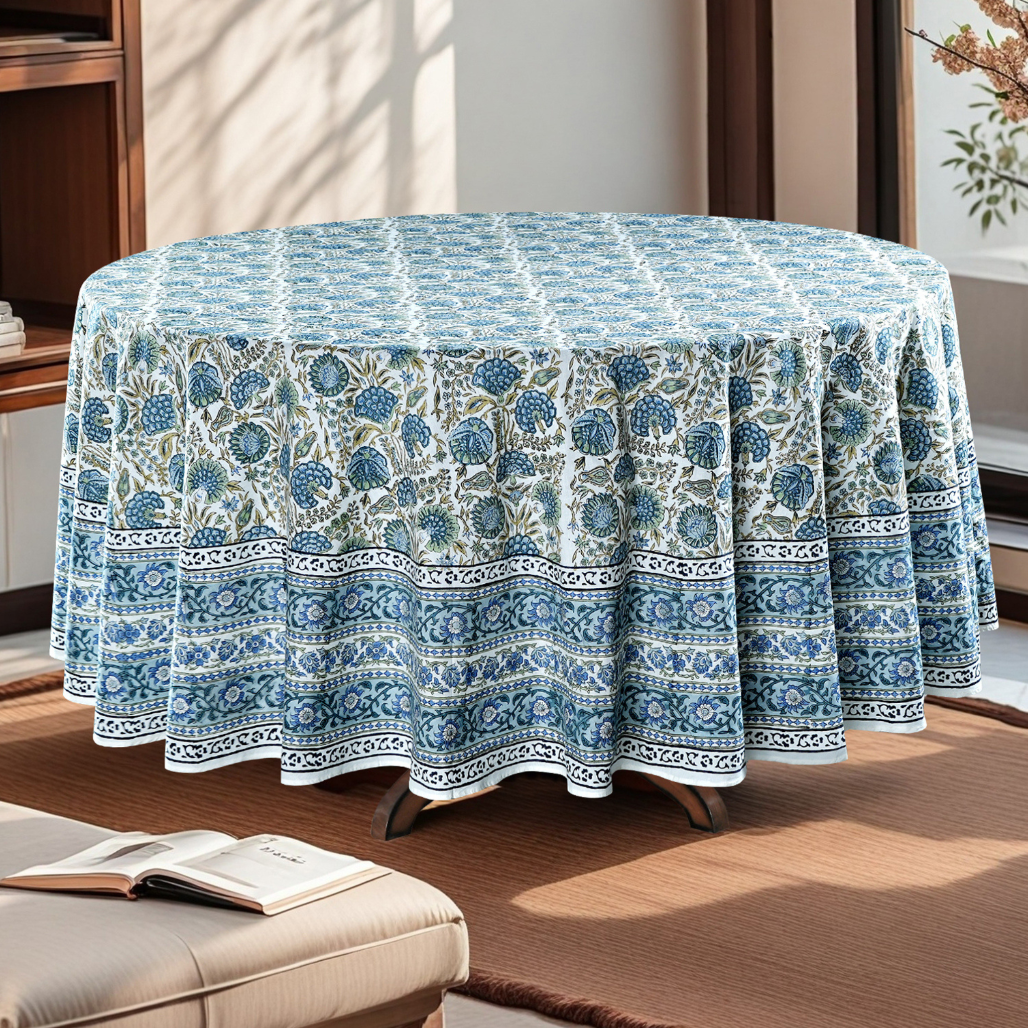Round table covered with a blue and white patterned tablecloth in a room.