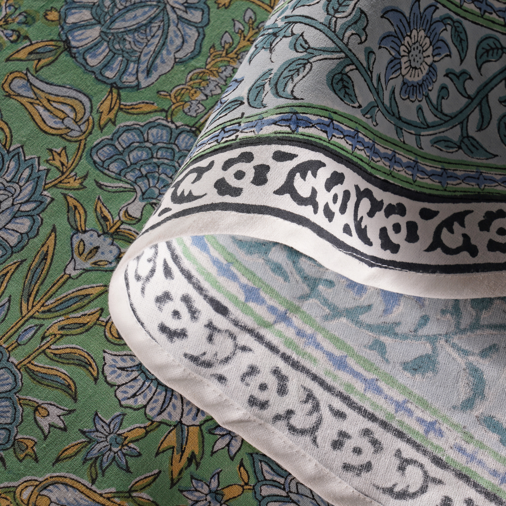 Close-up of a fabric with intricate patterns and text on a green background