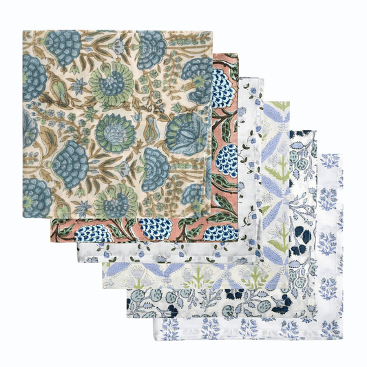 Set of four floral patterned napkins on a white background