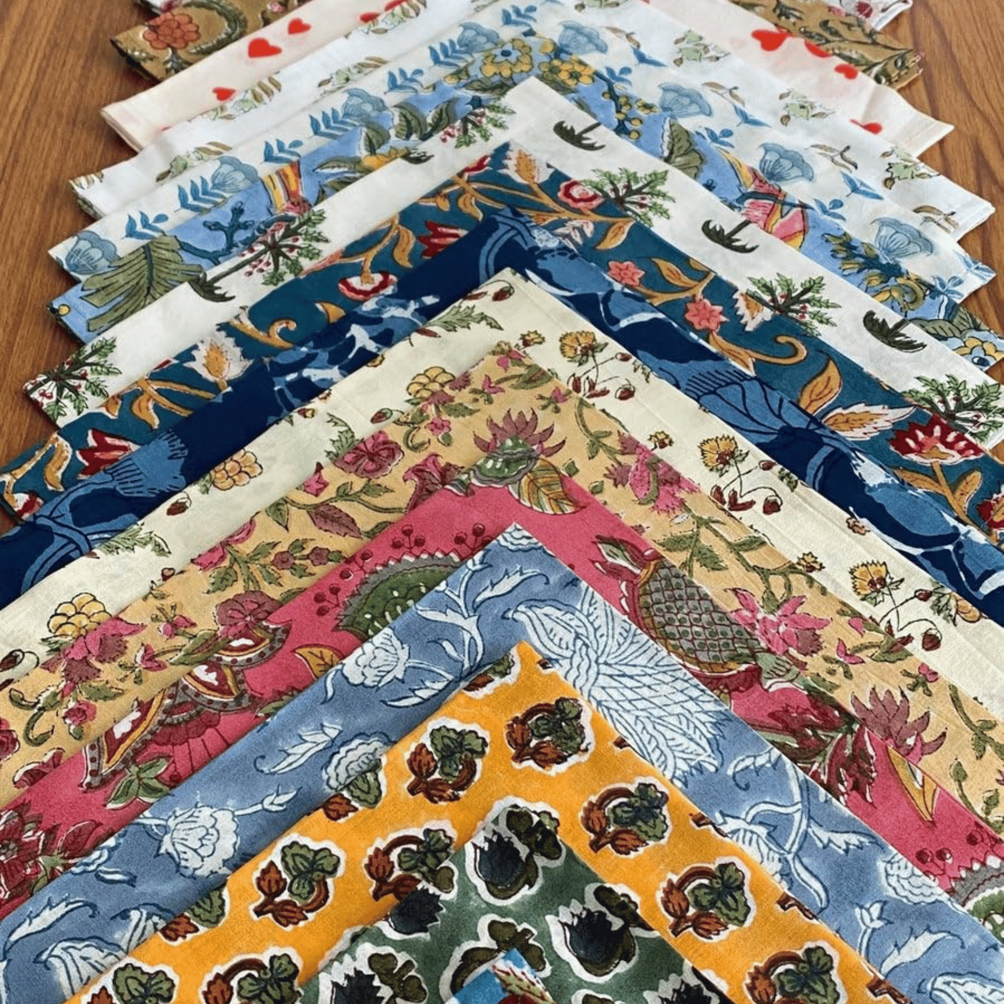 Collection of colorful fabric samples with intricate patterns on a wooden surface